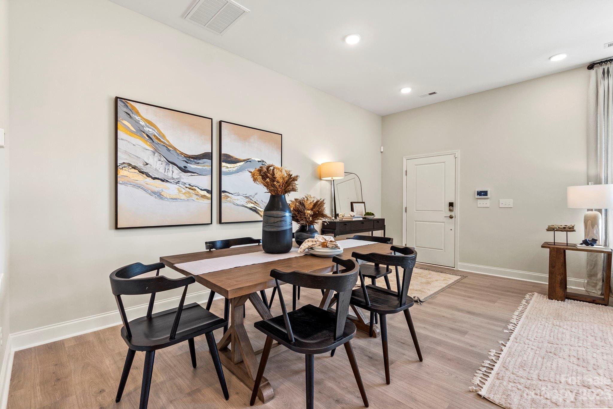8958 Morning Mist Road Harrisburg, NC 28215 - Photo 10 of 28 a view of a dining room with furniture and wooden floor