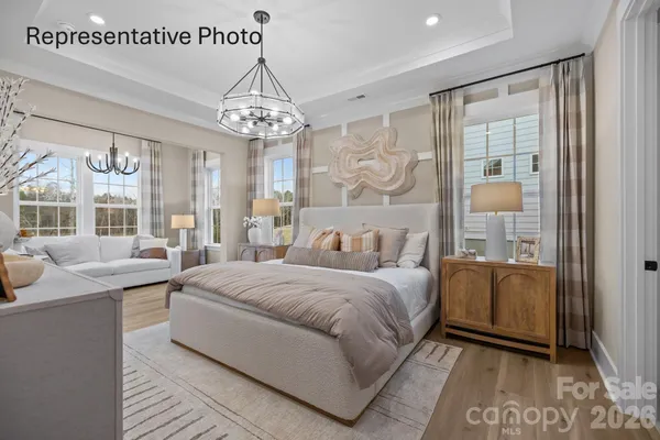 a spacious bedroom with a bed and a chandelier