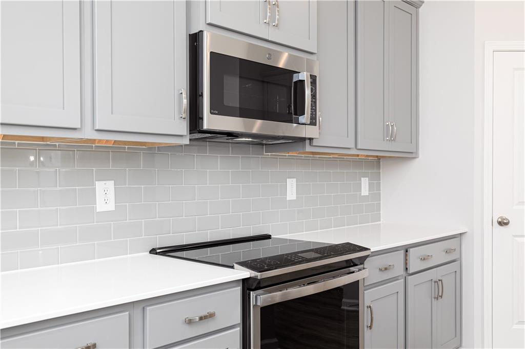 326 Cavalier Lane Acworth, GA 30102 - Photo 14 of 64 a kitchen with stainless steel appliances granite countertop white cabinets and a stove top oven