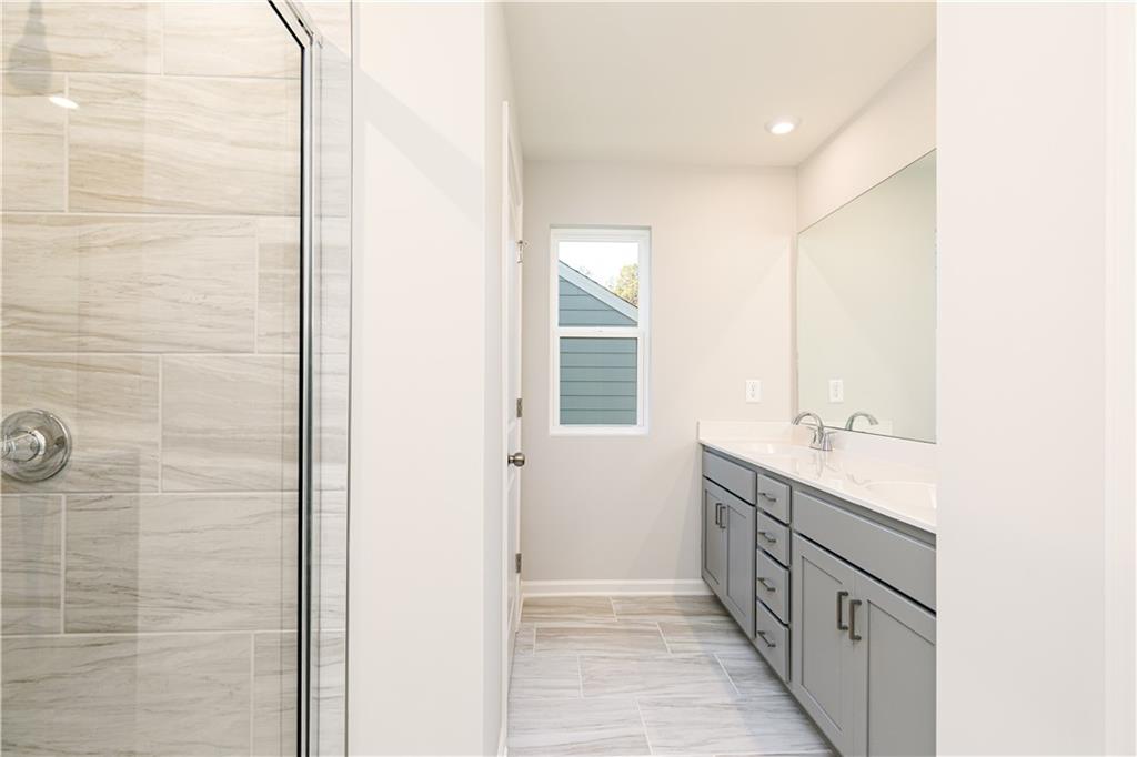 326 Cavalier Lane Acworth, GA 30102 - Photo 26 of 64 a bathroom with a double vanity sink a mirror and a shower