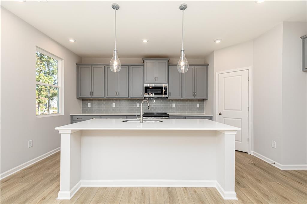 326 Cavalier Lane Acworth, GA 30102 - Photo 10 of 64 a kitchen with kitchen island a stove a sink a center island and wooden floor