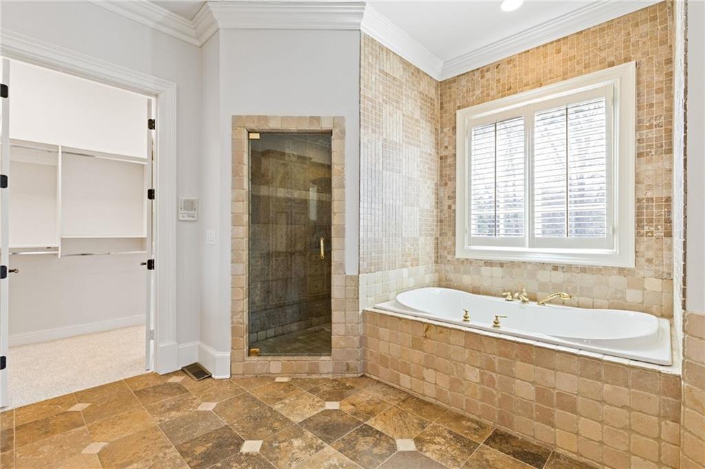 2010 Legends Way Braselton, GA 30517 - Photo 27 of 77 a bathroom with a tub a sink and a shower