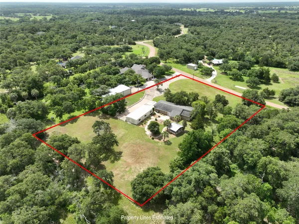 an aerial view of residential houses with outdoor space and trees