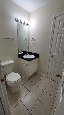 a bathroom with a granite countertop toilet sink and mirror