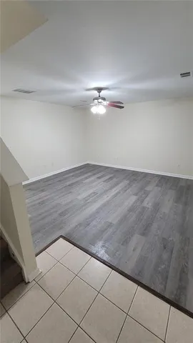 a view of a room with an empty space and a ceiling fan