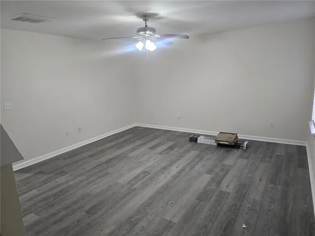 a view of a room with wooden floor and ceiling fan