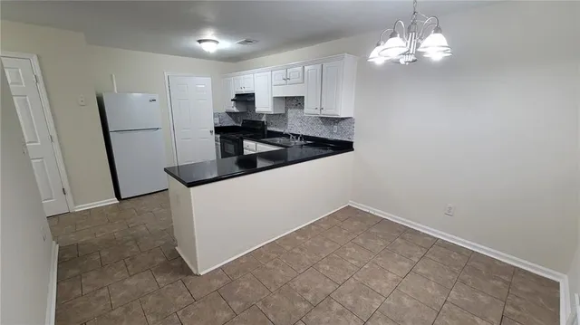 a kitchen with granite countertop a sink a stove and refrigerator