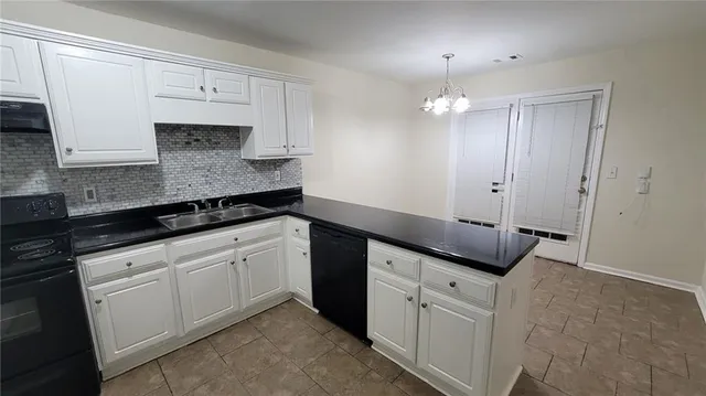 a kitchen with granite countertop white cabinets and black appliances