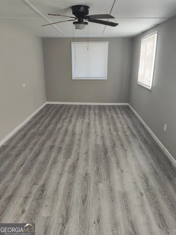 an empty room with wooden floor and window