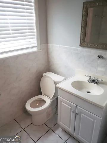 an empty room with wooden floor windows and fan