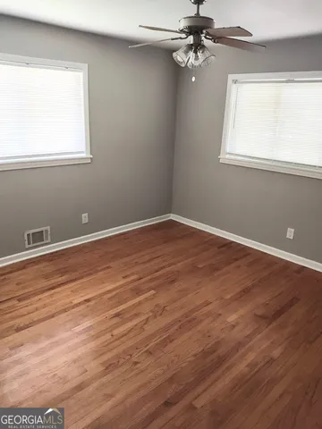 a view of a room with wooden floor and window