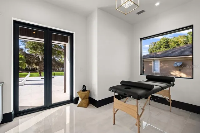 a living room with patio furniture and a potted plant