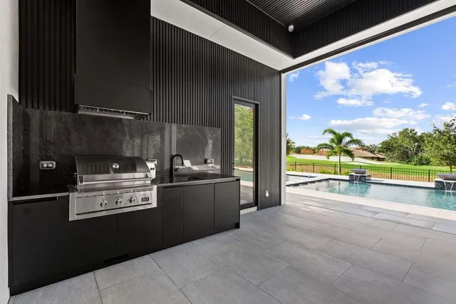 an aerial view of lake and residential houses with outdoor space and swimming pool