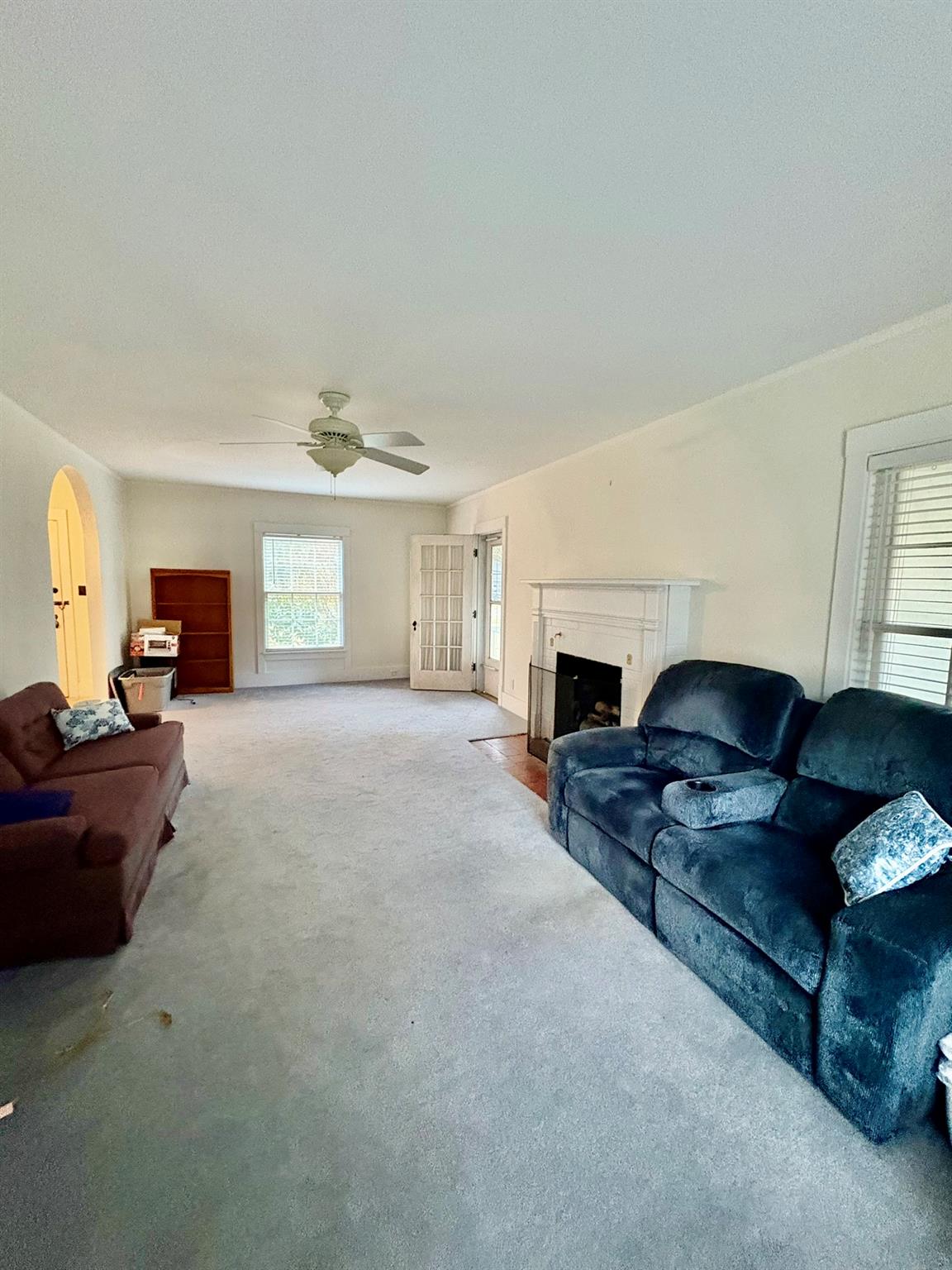 123 Rockland Road Roscoe, NY 12776 - Photo 13 of 31 Living area featuring a ceiling fan, carpet floors, arched walkways, and a fireplace with flush hearth