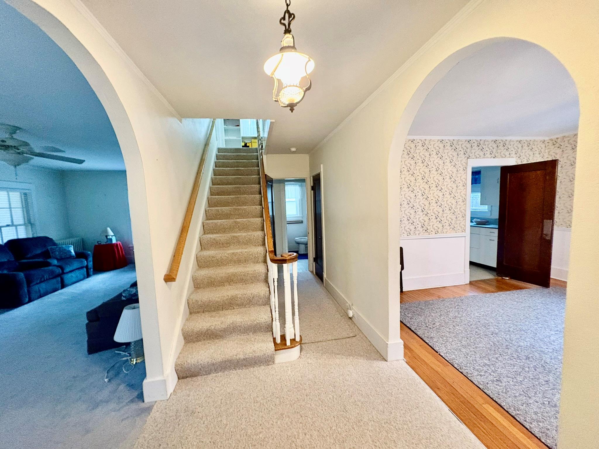 123 Rockland Road Roscoe, NY 12776 - Photo 17 of 31 Main Foyer Staircase featuring wainscoting, wallpapered walls, arched walkways, and ornamental molding