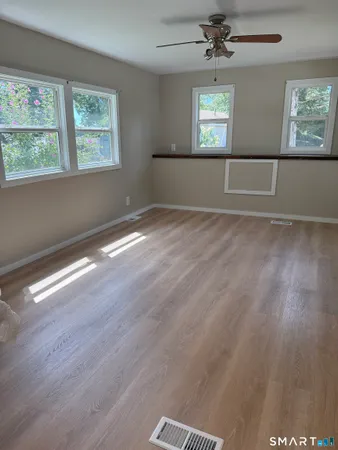 wooden floor in an empty room with a window