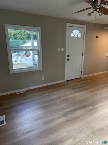 an empty room with wooden floor and windows