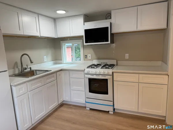 a kitchen with cabinets appliances a sink and a counter top