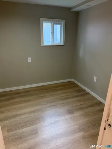 a view of a room with wooden floor and window