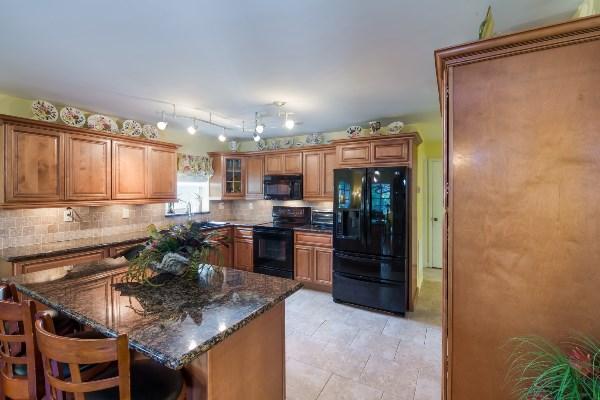 201 Oregon Lane Boca Raton, FL 33487 - Photo 6 of 31 a kitchen with kitchen island granite countertop a sink cabinets and stainless steel appliances