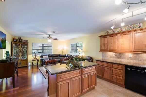 201 Oregon Lane Boca Raton, FL 33487 - Photo 9 of 31 a open kitchen with stainless steel appliances granite countertop a sink dishwasher a stove and white countertops with wooden floor