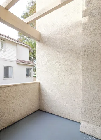 a view of a patio with a table and chairs and a barbeque