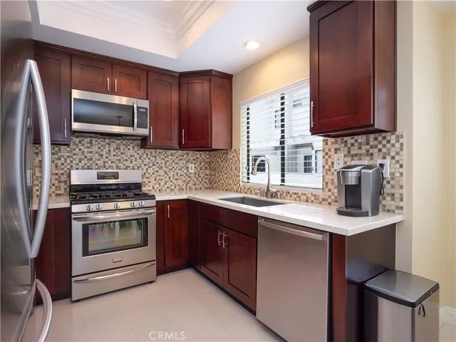 a kitchen with granite countertop stainless steel appliances and wooden cabinets