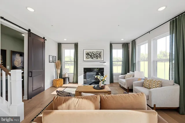 a living room with furniture large window and a fireplace