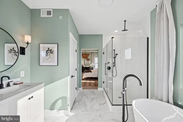 a bathroom with a tub a sink and a large mirror