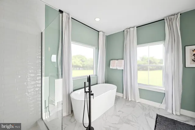 a spacious bedroom with a bed a chandelier and a couch