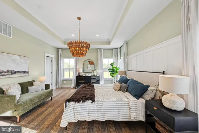 a spacious bedroom with a bed and a chandelier