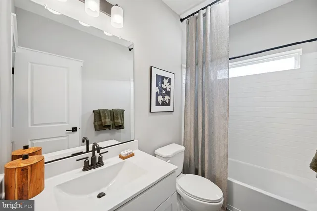 a bathroom with a sink a toilet a mirror and shower