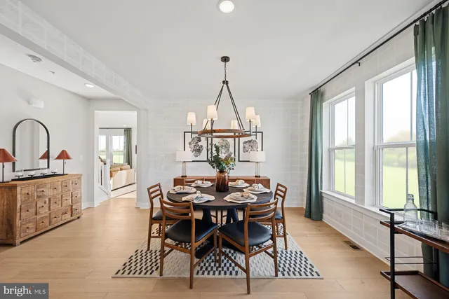 a dining room with furniture a chandelier and wooden floor