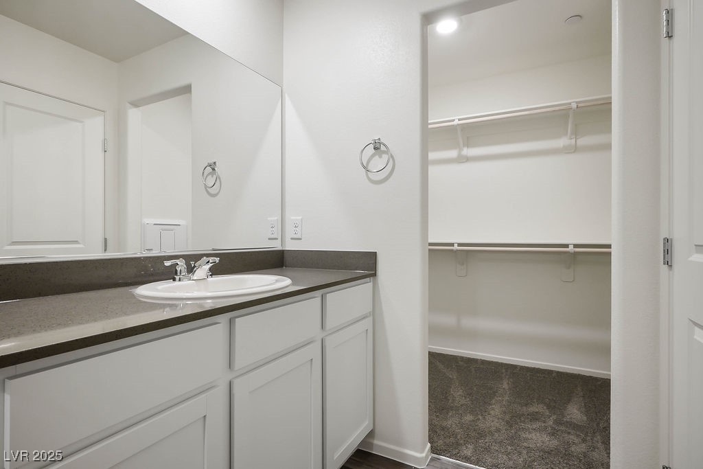 6184 Hibiscus Gdn Street North Las Vegas, NV 89081 - Photo 21 of 35 Bathroom featuring vanity, a walk in closet, and dark colored carpet