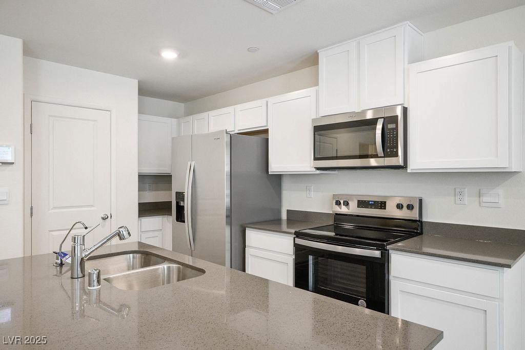 6184 Hibiscus Gdn Street North Las Vegas, NV 89081 - Photo 8 of 35 Kitchen with stainless steel appliances, dark stone countertops, white cabinets, and recessed lighting