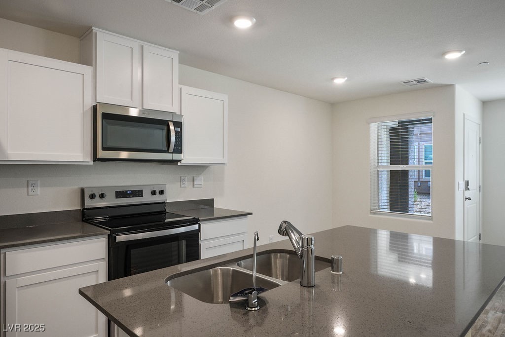 6184 Hibiscus Gdn Street North Las Vegas, NV 89081 - Photo 9 of 35 Kitchen with stainless steel appliances, white cabinetry, dark stone countertops, and recessed lighting