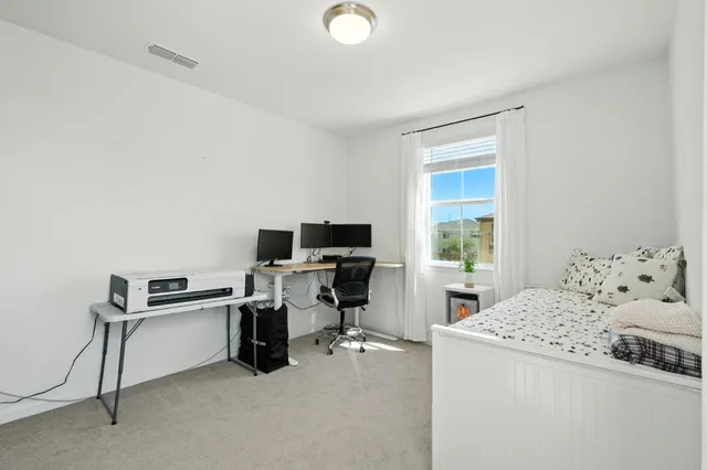 a view of a workspace with furniture and a window