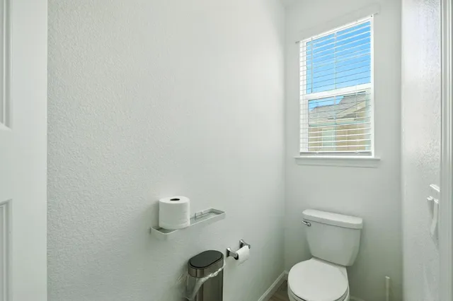 a bathroom with a toilet a sink and mirror