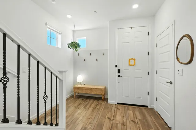 a view of a hallway with wooden floor and staircase