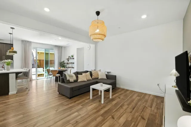 a living room with couches and a flat screen tv with wooden floor