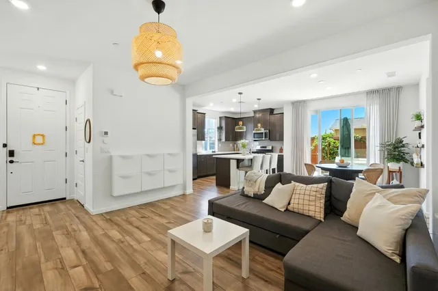 a living room with stainless steel appliances kitchen island granite countertop furniture and a wooden floor