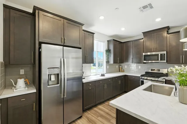 a kitchen with stainless steel appliances a refrigerator stove microwave and sink