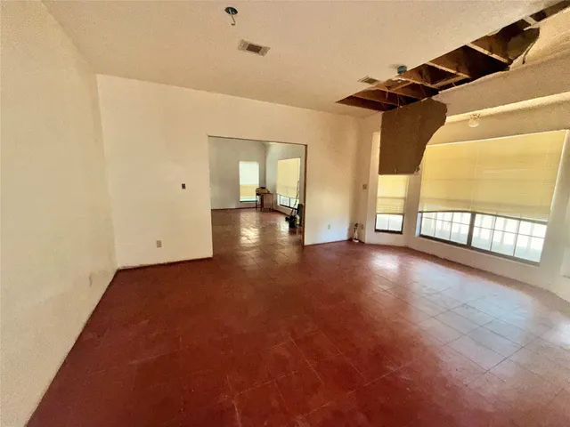 an empty room with windows and chandelier