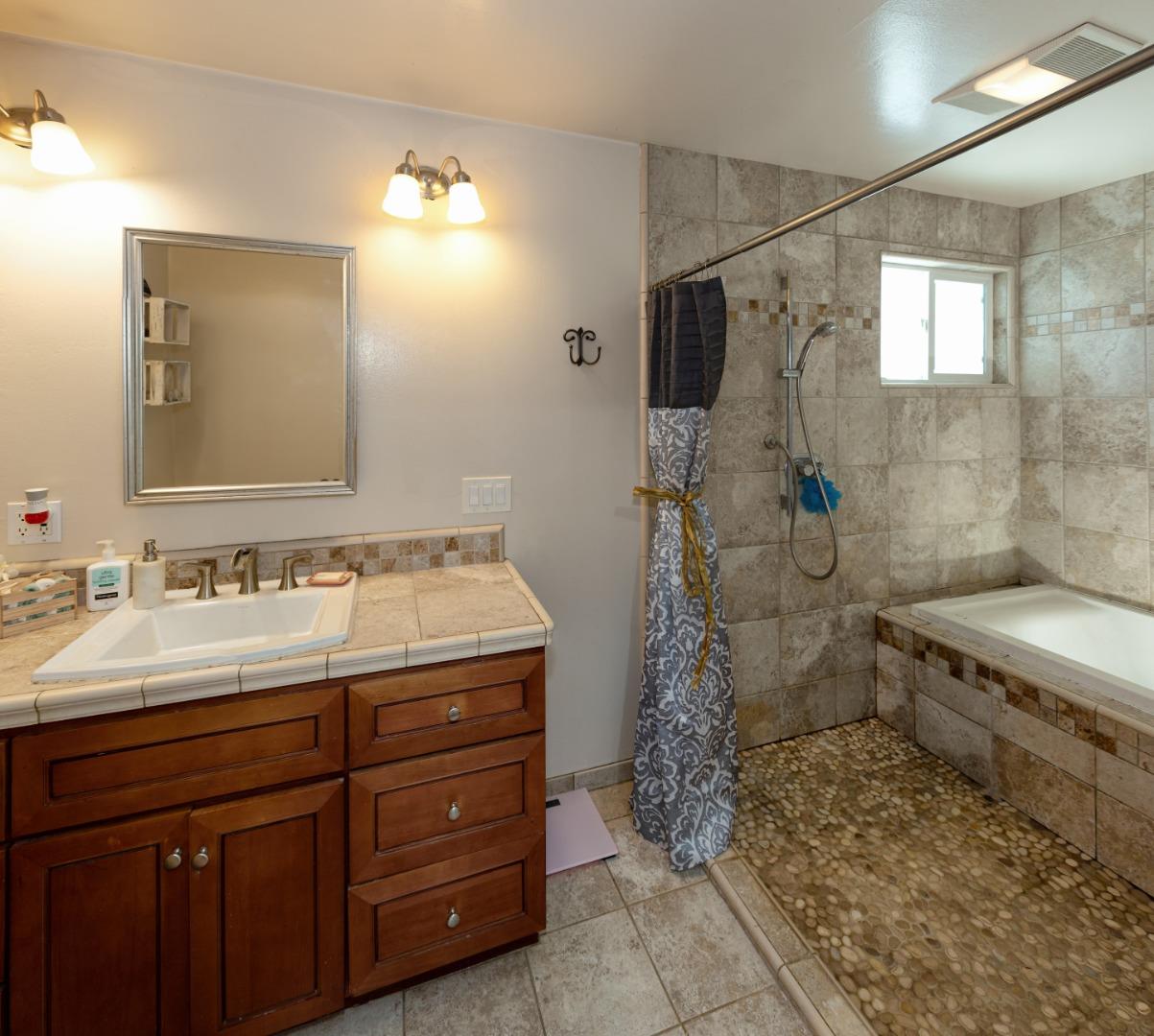 100 Smith Road Watsonville, CA 95076 - Photo 12 of 25 a bathroom with a granite countertop sink a mirror and a shower