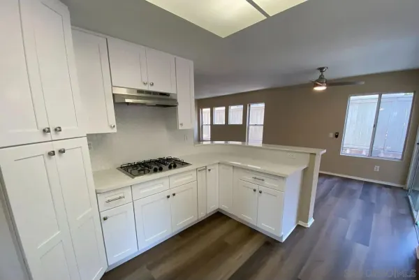 a kitchen with appliances cabinets and a wooden floor