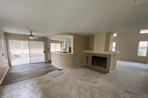 a view of an empty room with a fireplace and a window