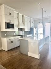1315 West 24th Street, Unit B Houston, TX 77008 - Photo 7 of 26 a kitchen with stainless steel appliances kitchen island granite countertop a sink a stove and cabinets