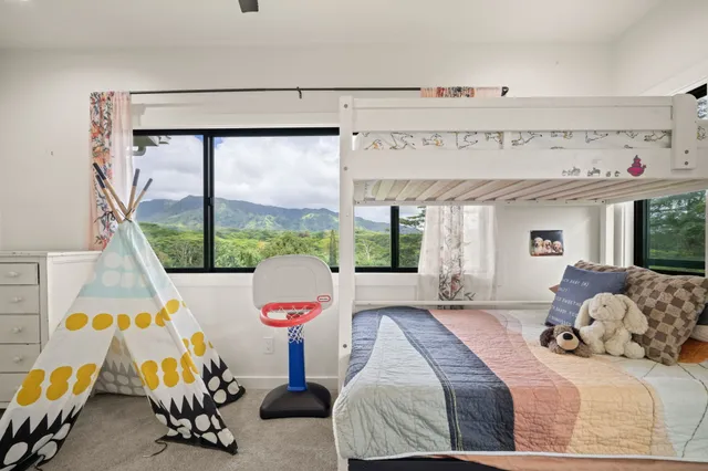 a bedroom with a bed and large windows