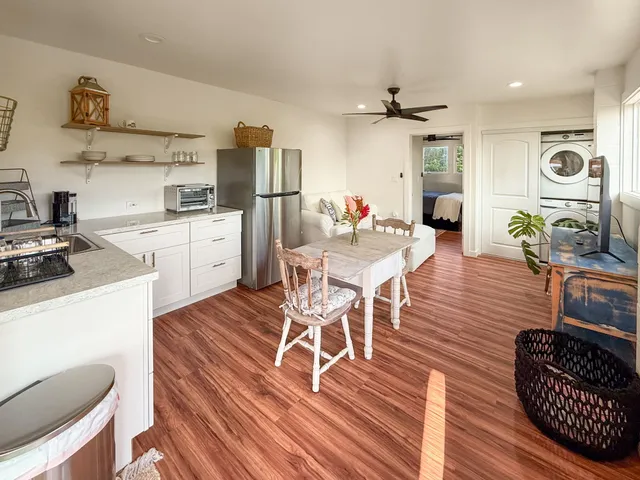 a dining room with wooden floor a chandelier a wooden table and chairs