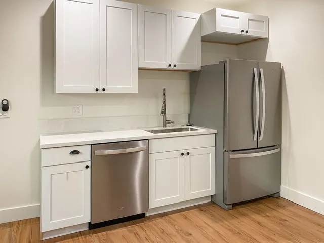 a kitchen with a refrigerator sink and cabinets